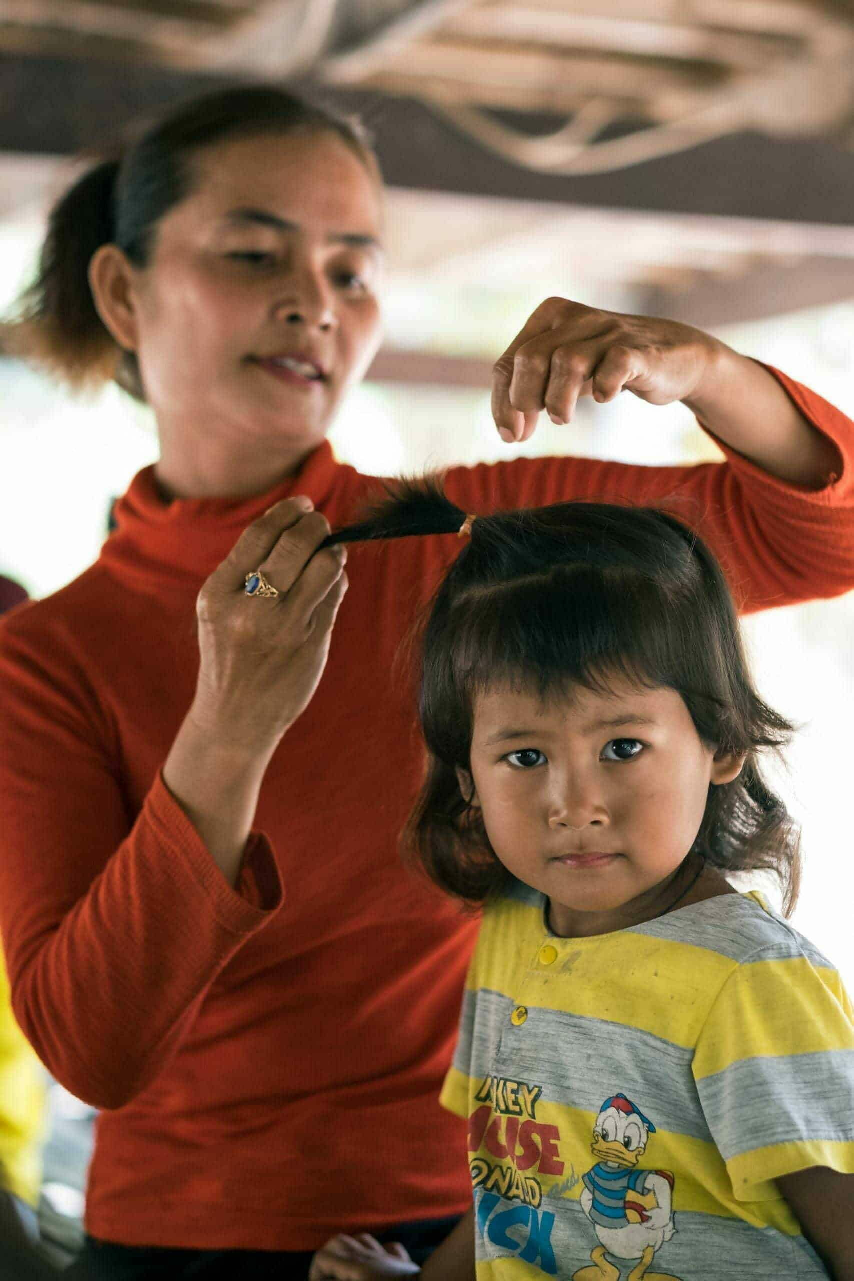 A Children in families foster mum brushes her daughters hair