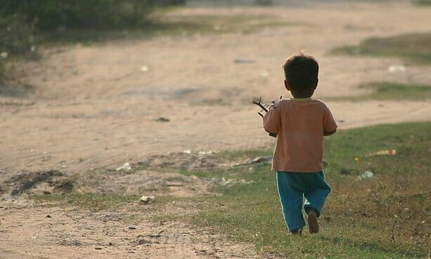 Child carrying sticks back home