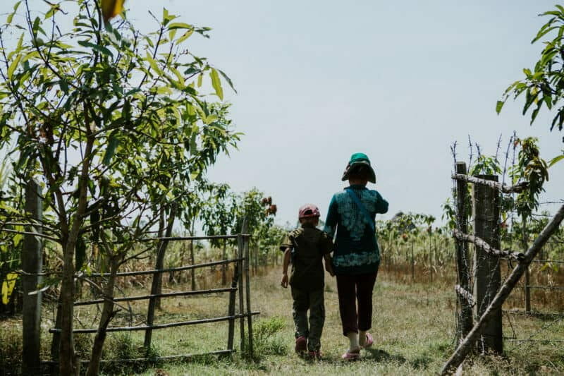 mother and child walking in field