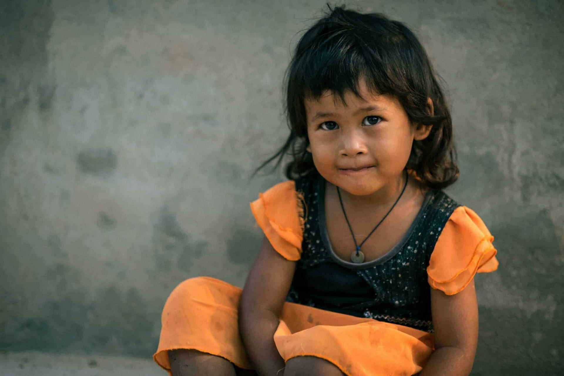 young girl looks at the camera and smiles - donate to CIF ABLE program